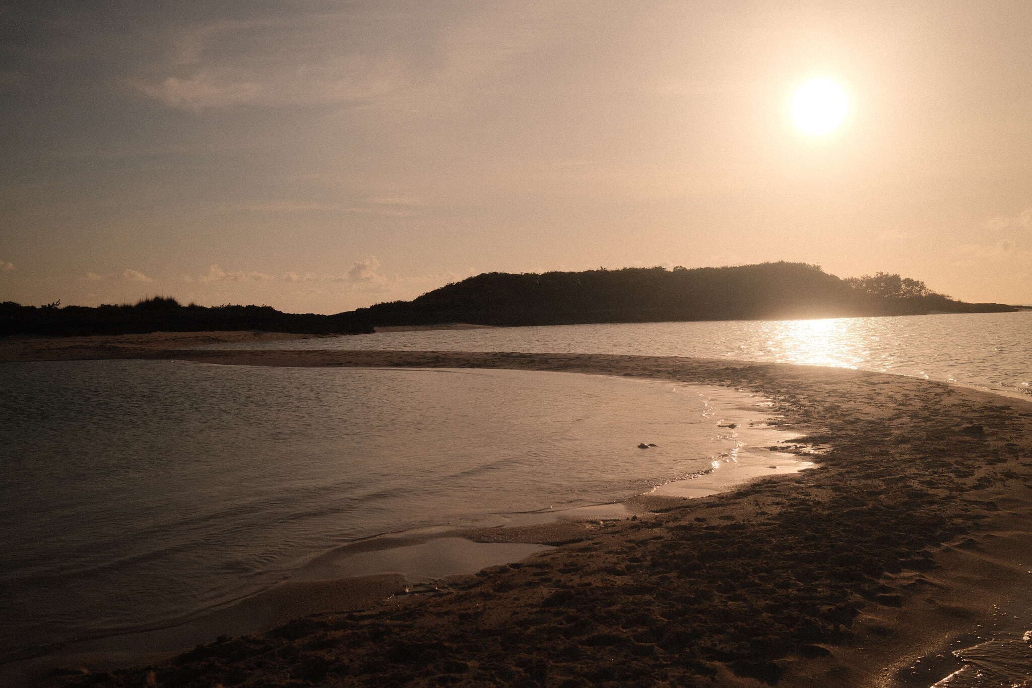 Sunset behind island — golden reflections, Exumas