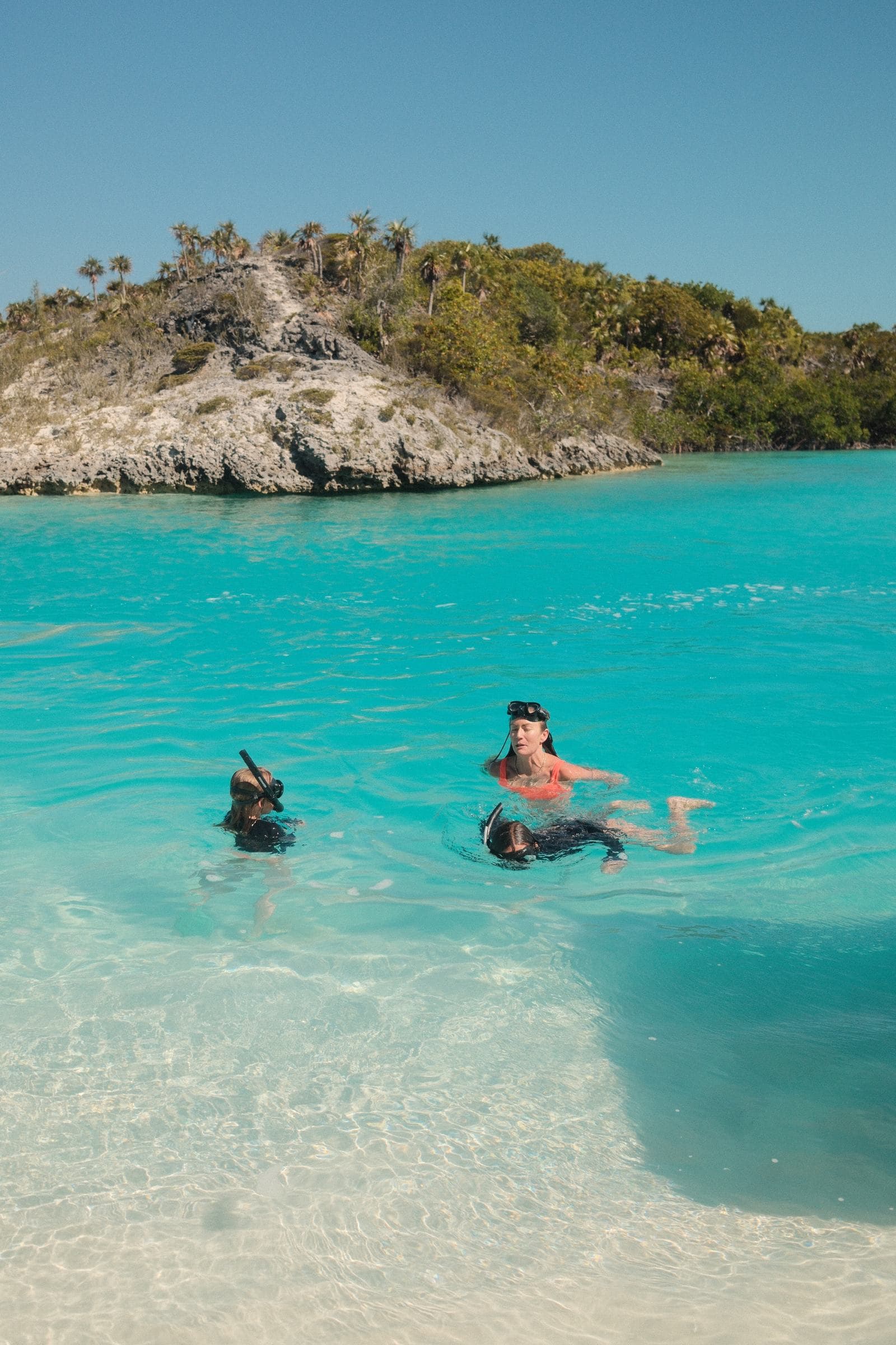 Family snorkeling in clear water near Warderick Wells — Exumas, Bahamas