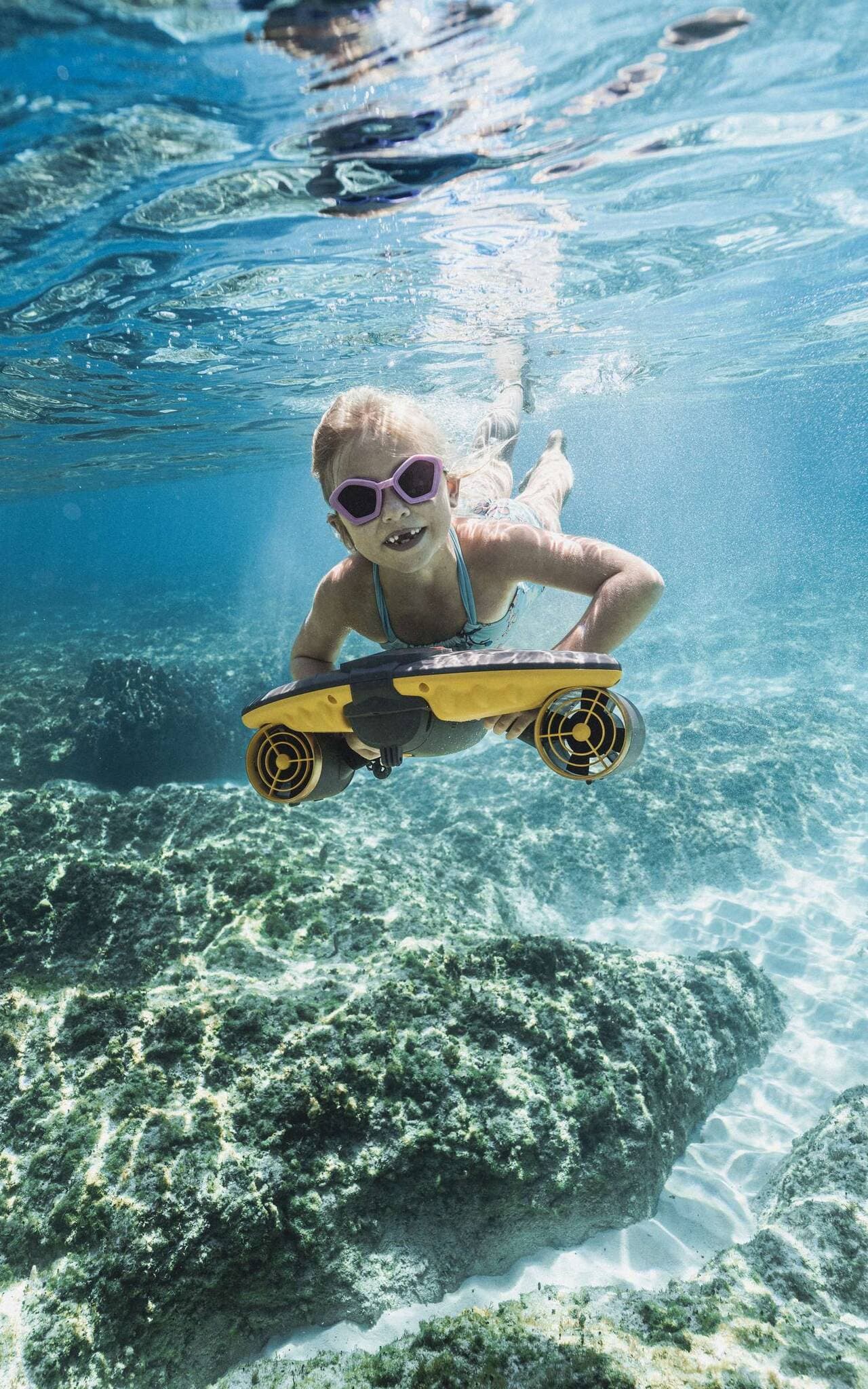 Sea scooter girl on reef