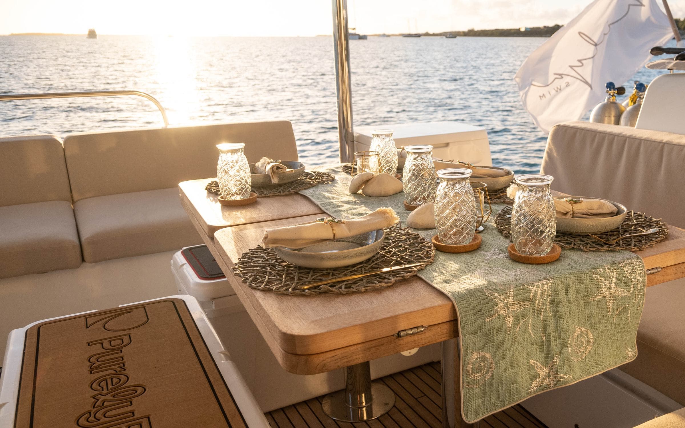 Sunset table setting on aft deck — PurelyBlu branded