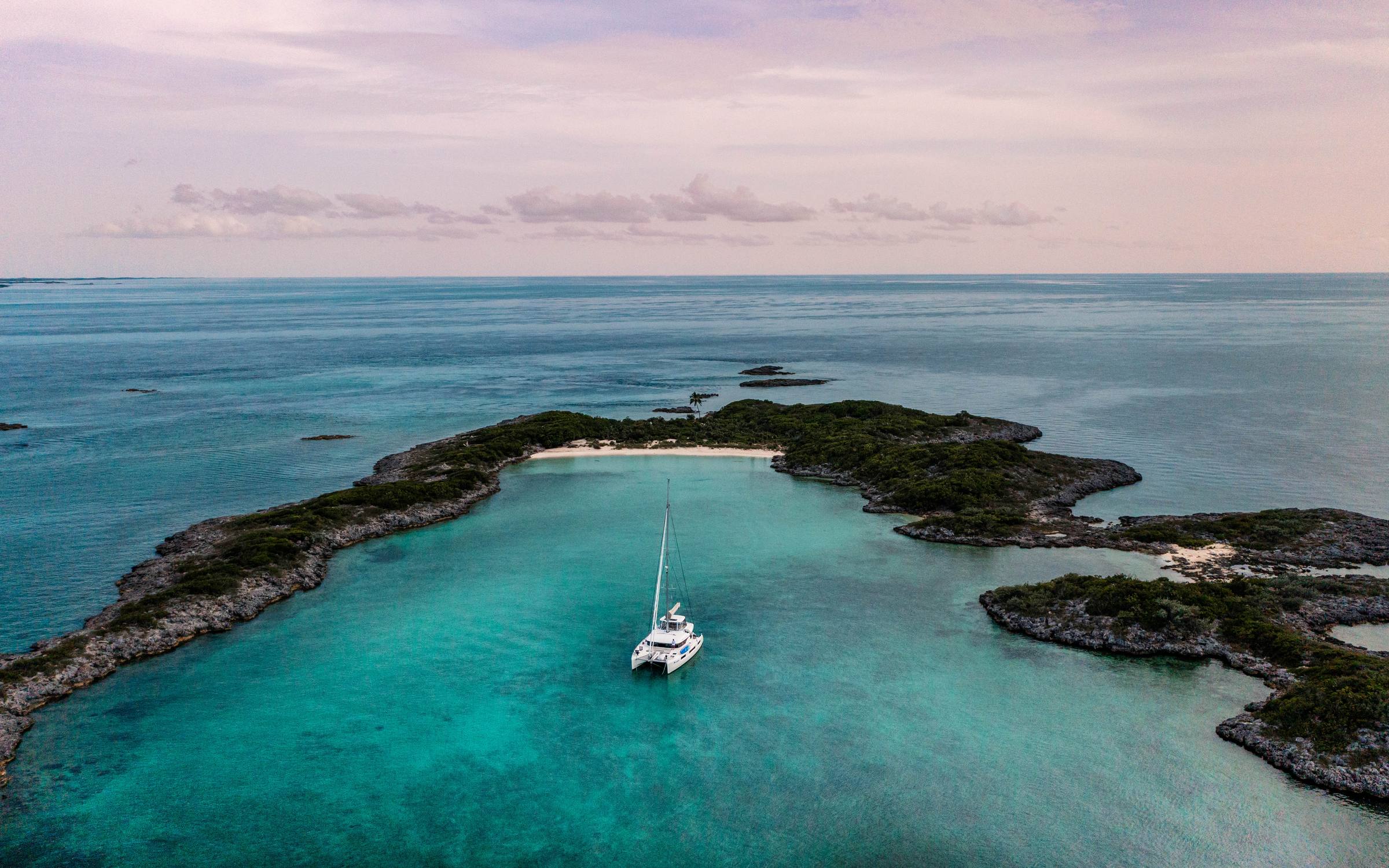 Catamaran at anchor in a cove at dusk — Exumas, Bahamas