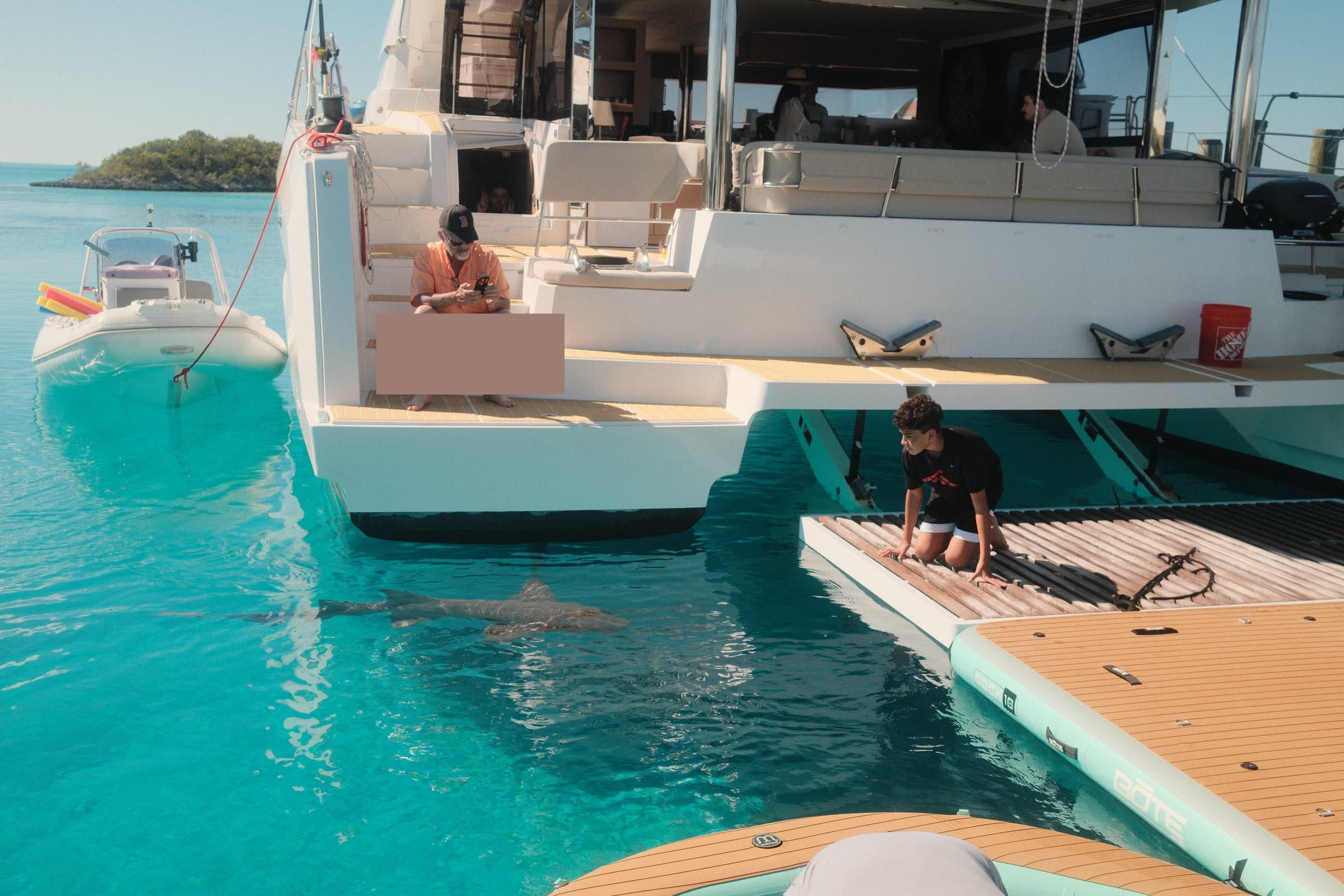Guests with nurse sharks beside the yacht at Compass Cay — Exumas, Bahamas
