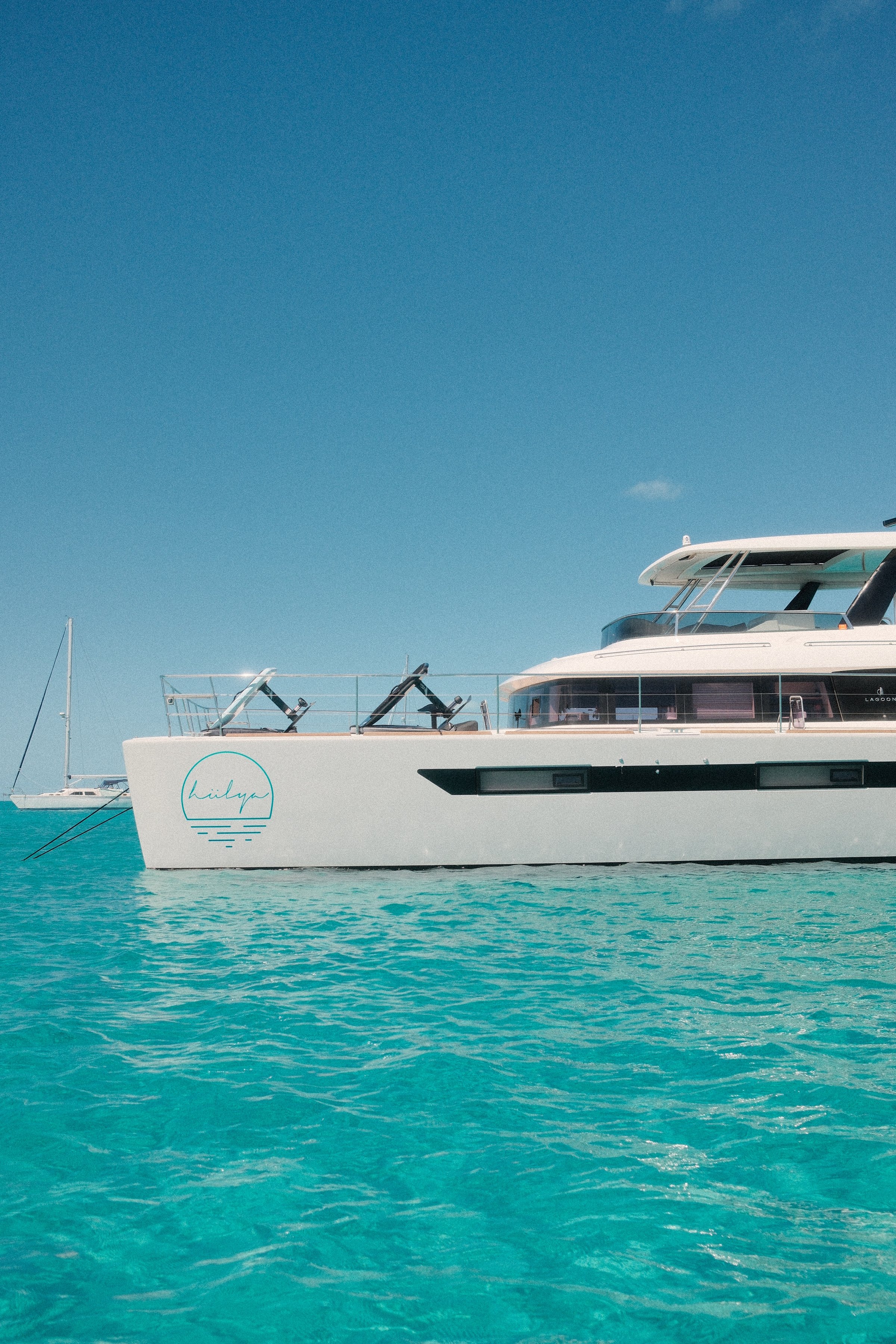Catamaran at anchor in crystal turquoise shallows — Exumas, Bahamas