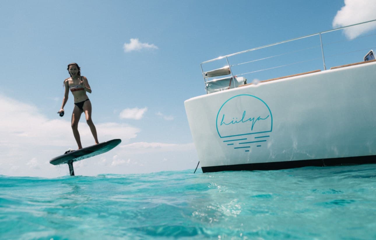 Guest eFoiling in turquoise Exumas water — aerial view